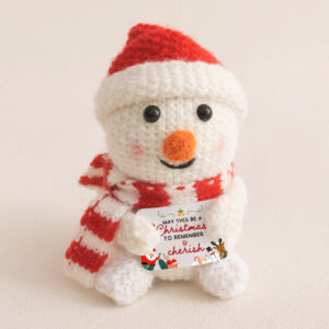 Cute crochet Christmas snowman with red hat and scarf, holding a festive card, perfect crochet decor for Christmas