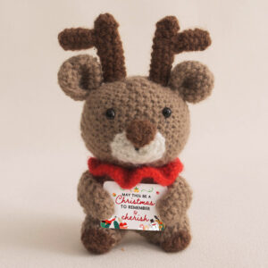 Handmade crochet reindeer, a perfect Christmas doll for holiday decor, with cute antlers and a festive message