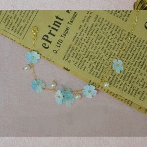 Handmade micro-crochet floral bracelet with pink/purple blooms and pearl accents. Delicate crochet jewelry from a micro-crochet factory, perfect as a handmade gift for her.