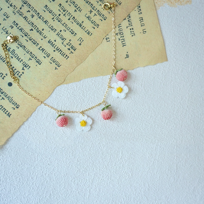Delicate handmade crochet bracelets featuring micro strawberry and flower ornaments, ideal for wholesale crochet jewelry suppliers.