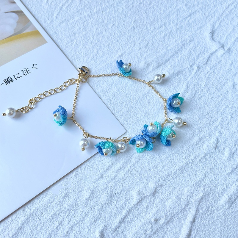 Delicate hand crochet bracelets featuring blue micro-flower ornaments and pearls, offered by a wholesale crochet jewelry supplier.